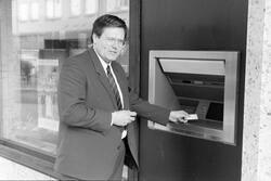 Tekst: "En ny utendørs minibank er nå montert utenfor DNC i Kristiansund. Rolf Nergaard i DNC venter at minibanken vil bli tatt i bruk i løpet av neste uke." Det skriver Nordmørsposten,  4. februar 1987. Fotograf er Jan Øivind Jensen.