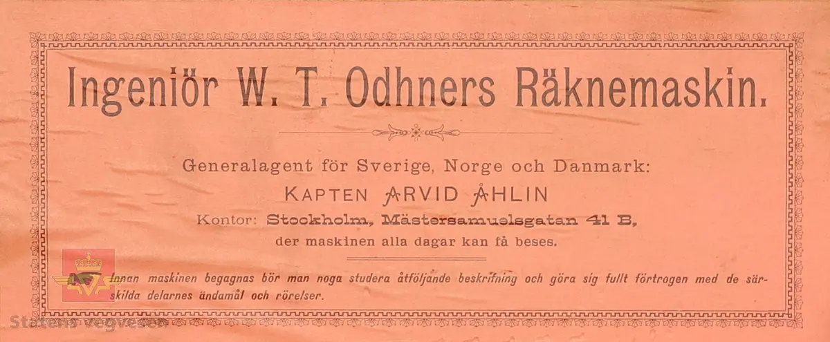 Mekanisk regnemaskin laget av metall som har et sveivehåndtak. Regnemaskinen sitter i en tre kasse med lokk, og med messingslås og trehåndtak. Regnemaskinen er gullfarget og svart, og er dekorert med logo. Sveivehåndtaker er sølv og brun farget og laget av tre. Inne i kisten henger en lapp. 