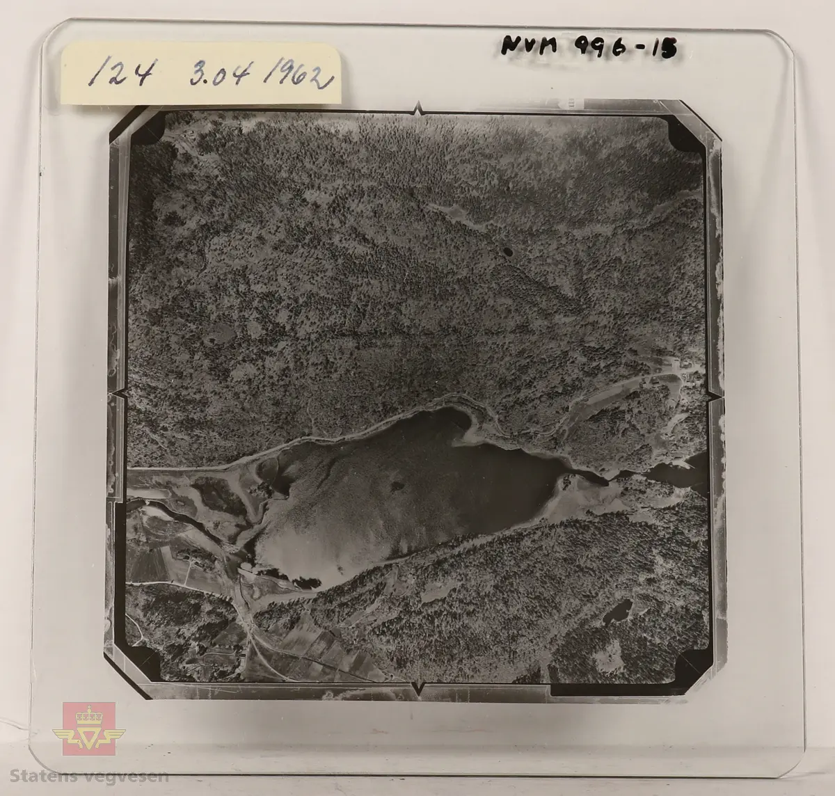 19 stk landskapsfoto på glassplate i svart/hvitt. Fotografiene er flyfoto i fugleperspektiv, langt over selve landskapet. Ligger samlet i en eske i egne små beskyttelses poser av papir. Merket med lapper mellom. 