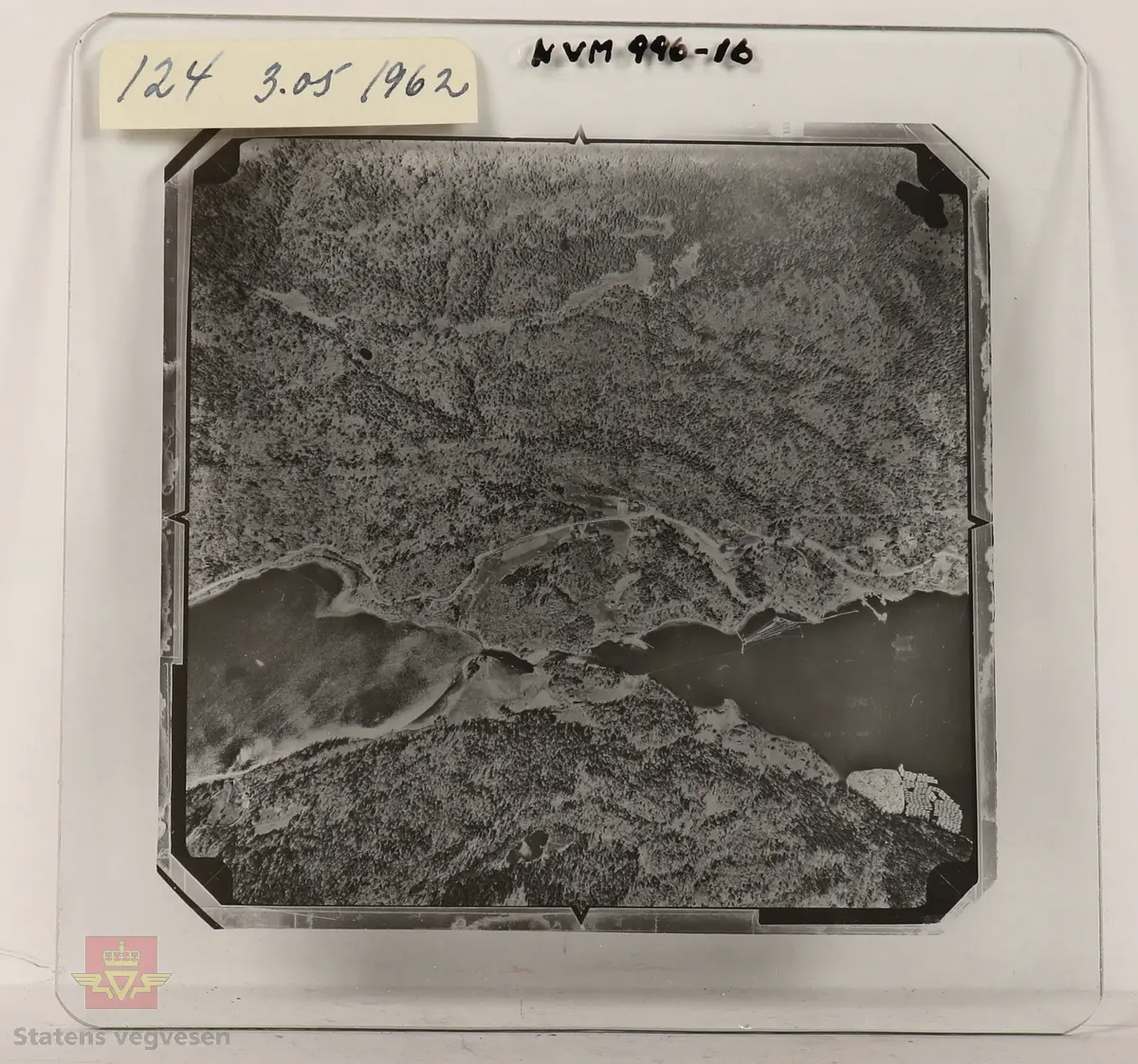 19 stk landskapsfoto på glassplate i svart/hvitt. Fotografiene er flyfoto i fugleperspektiv, langt over selve landskapet. Ligger samlet i en eske i egne små beskyttelses poser av papir. Merket med lapper mellom. 