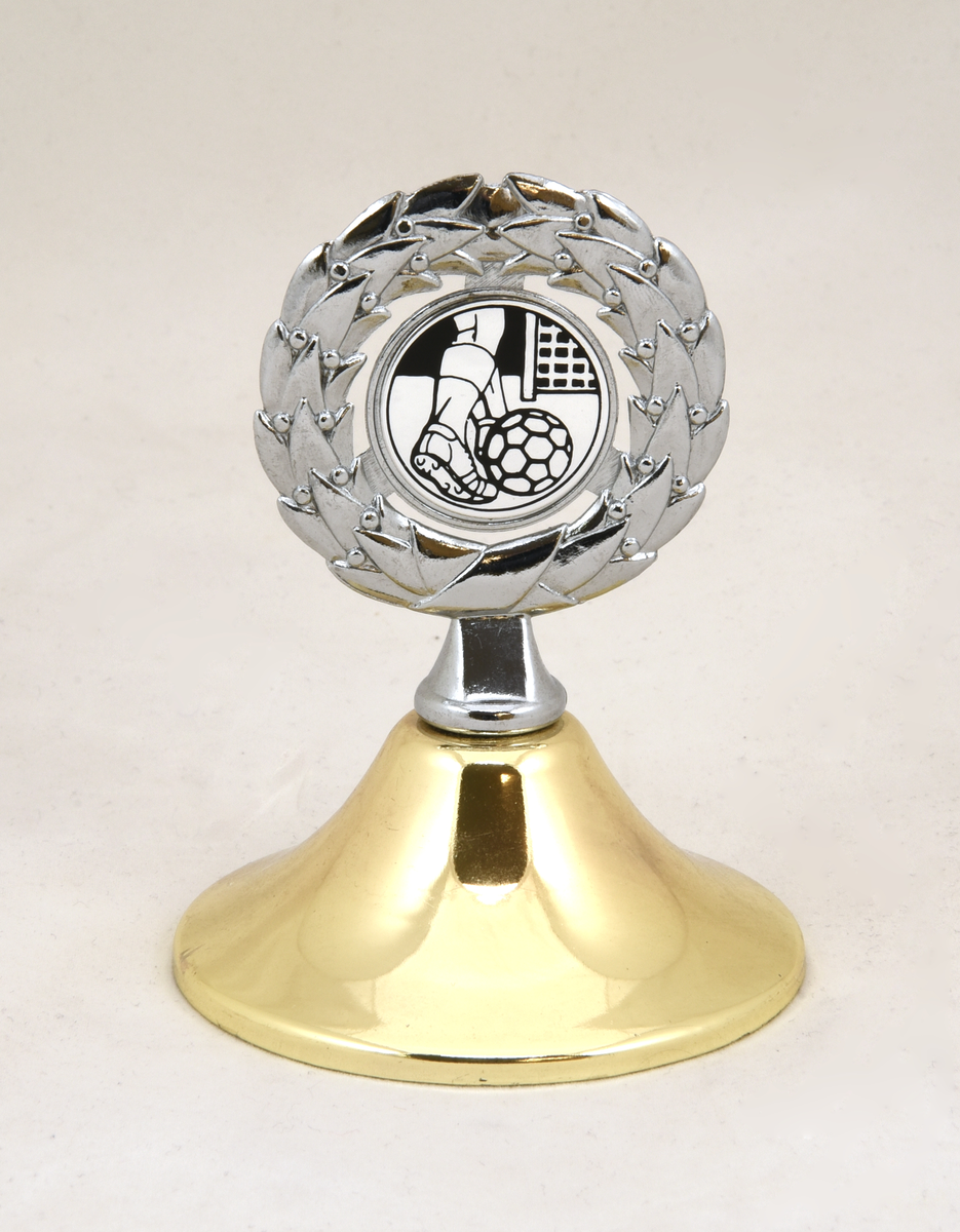 Pokal (:1) med guldfärgat lock (:2), och fot av grå stengods. På locket upptill en lagerkrans med en illustration i form av en fotbollsspelares ben som skjuter bollen mot mål. Pokalens överdel består av en silverfärgad metallskål som är guldfärgad på insidan. Fastlimmad guldfärgad metallbricka på foten med text "MIXED 1994 SJ SPORT G". Det finns ytterligare en etikett på pokalens undersida vars ytskikt är bortnött.