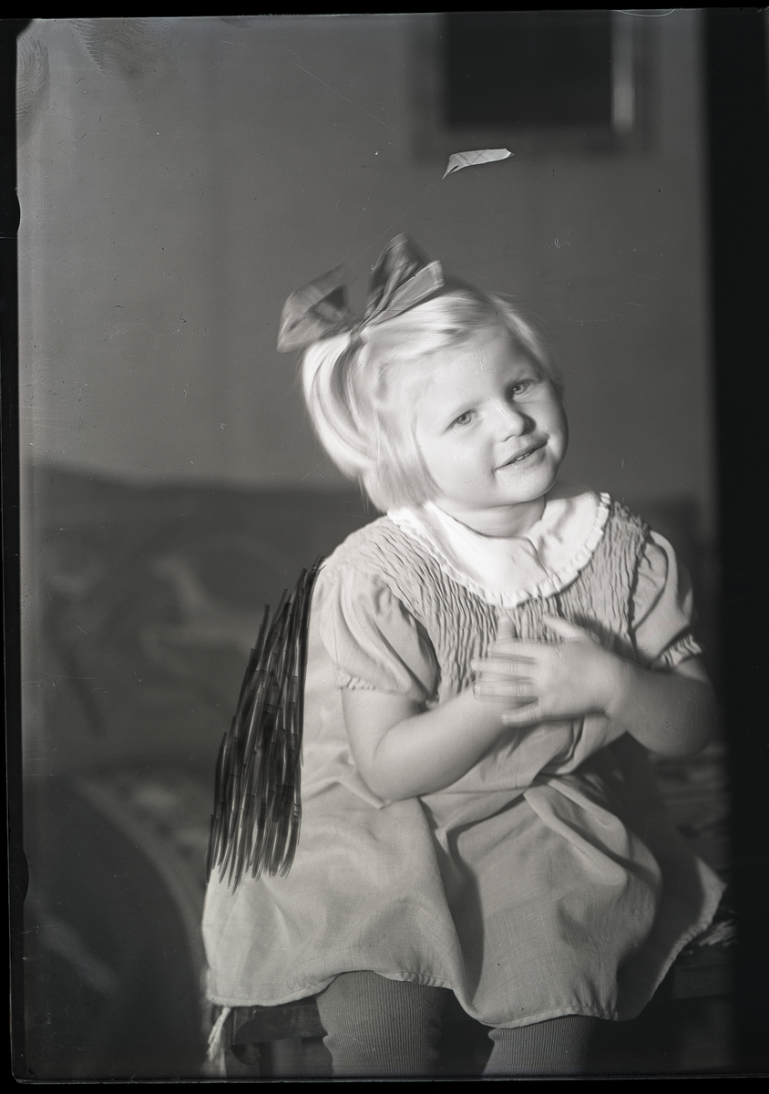 Foto av ukjent jente, fornavn Tulla (basert på brev som medfulgte foto). Trolig tatt på 1930-tallet eller tidlig 1940-tallet

Et brev medfulgte foto: 

Hr. fotograf Jensen!

Hjertelig takk for billeder. Det var noen strålende resultat. Vi blev  (?) oss begeistret. Det skal bli noen flotte prospekt-kort også. Vi ka(?) ved(?) snart så skal vi ka(?) i(?). Der fireløbig nu skal jeg få bestille 2 billeder av Tulle.  ... (?) med hendene på bryst. Det var his bedårende. jeg skal sende de i julepresang, så jeg vilde sie takk (?) jeg fikk de snart. Hjertelig hilsen fra os alle på Brokefjell, Anna Midt-Rud (?) 

Spesiel hilsen til telegrafen fra Tulle som (?) fortalte af (?) bled så glad i