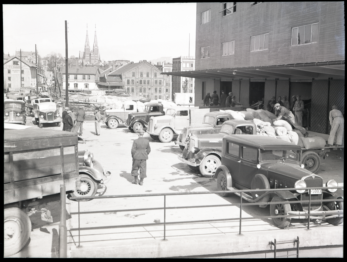 Foto av Skiens aktiemølle i 1940

Skien kirke i bakgrunnen 

Bilene på høyre side: H-5003 Hudson 1931, registrert eier: Reidar Andersen, Skien (Telemarks Bileier 1938). 
Deretter lastebilene Fargo 1937-38, Ford V8 1937, Opel Blitz, Ford V8 1936, Chevrolet 1937

Påskrift på konvolutt foto lå i:

Skiens Aktiemølle 12/4 - 40
