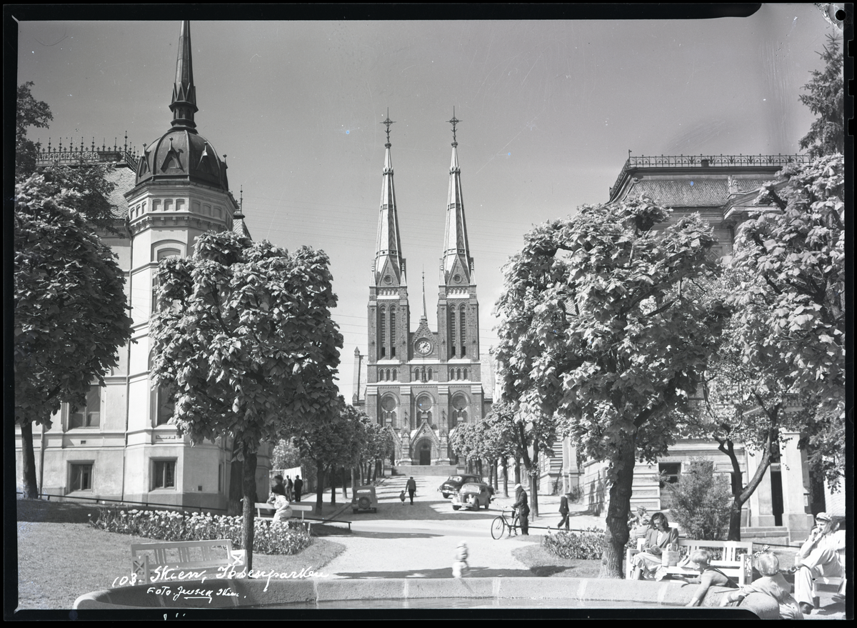 Foto av Skien kirke tatt fra Ibsenparken i sentrum av byen 

Til høyre (bak trærne) kan man se deler av Festivitetentil høyre og Skien Sparebank til venstre.

Påskrift på konvolutt:

Skien kirke tatt fra Ibsenparken