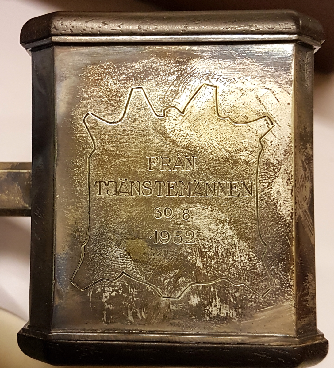 Ordförandeklubba i silver och trä. Ligger i tillhörande etui.  Inskription LA Mattons läderfabrik AB, Gefle. Från tjänstemännen 30/8 1952. Inuti locket står tryckt: Wåhlbergs juvelerarfirma Gävle-Karlstad.
