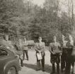 Grupp står vid Volvo PV-personbil, Intendenturfältövning våren 1957.