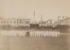 Män uppställda på gräsmatta under gymnastikfesten, 1891.