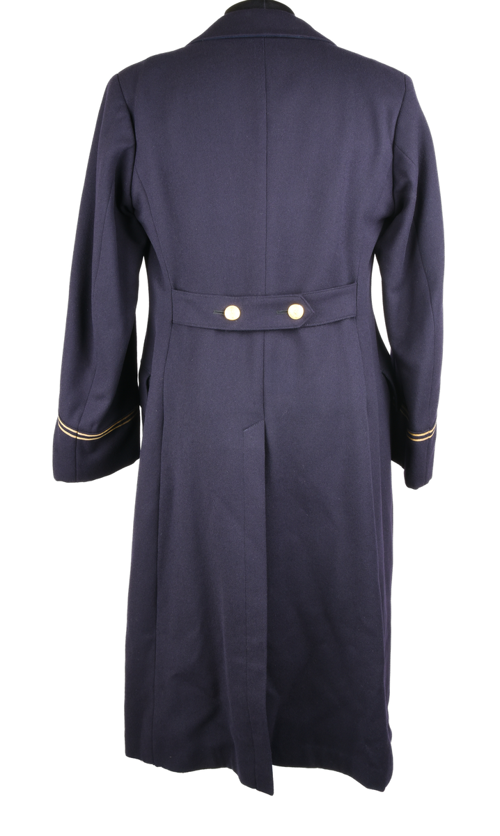 Rock av blått ylle, med sidenfoder. Dubbelknäppt med åtta knappar i gulmetall. Knapparna med krönt vinghjul tillhör 1909 års uniformsreglemente. Framtill två fickor med lock i midjehöjd. Två innerfickor i brösthöjd. Vid kragen en hank för upphängning av kavajen. Baktill sprund och slejf med två knappar. Gradbeteckning för kontorist vid ärmarna. 
Vid vänstra ärm, etikett med text: 
"FÖRSVARETS FABRIKSVERK 
Centrala beklädnadsverkstaden
Order: 23074
Verk: S.J. 24 ts.
Namn: Lindsén 18/4
Adress: Sthlm-Norra
egna galoner lämnade
Grad: Knt.
Tyg nr:
Utförande: Sidenfoder
Mått: 117-64½
Lev. tid:
Anm.:"
