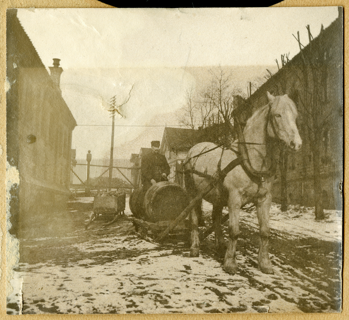 Foto av formann på Lundetangen bryggeri Karl Halvorsen (1853 - 1933) sittende på øltønner som blir slept av hest. Bryggeriet er murbygget som sees til høyre i foto

Foto nr. 2 er retusjert av fotoarkivar

Påskrift bak foto:

Karl Halvorsen Goberg [...]
på Lundetangen bryggeri
Var stallmester
