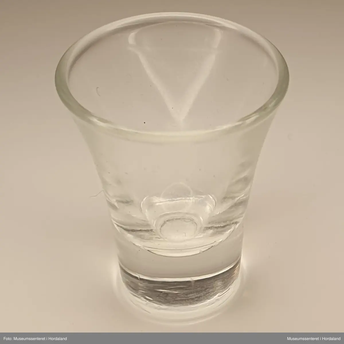 Lite glassbeger med konisk form.