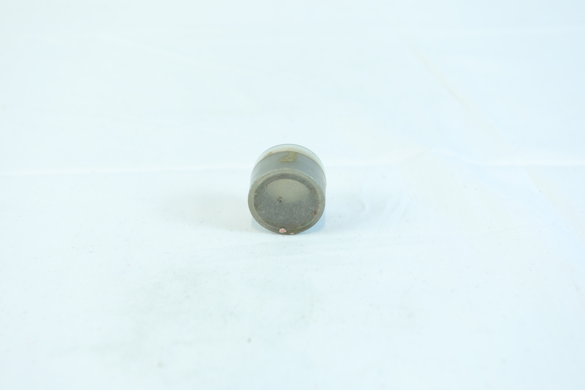 Rund liten boks i plast til oppbevaring av 7 sirkelformede metallringer. Trolig utstyr til verktøy.