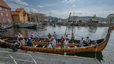 Vi ser vikingsskipet Håkon Håkonsson som gjør seg klar til å dra ut med mennesker om bord