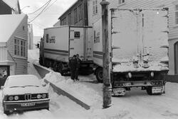 Tekst: "Beatebakken - en flaskehals. Hver vinter opplever vi at langtransporter på vei til Norfinn på Innlandet kjører seg fast i Beatebakken. I går morges skjedde det igjen. Fra klokken 8 og i et par timer framover sperret bilen fra Linjegods all annen trafikk. Folk fra Sjursvika på vei til jobb måtte ta beina fatt, og  enkelte var bekymret for hva som kan skje hvis det blir behov for ambulanse eller brannbil mens den eneste adkomstveien er sperret av en trailer full av fisk." Fra Nordmørsposten, 19. februar 1987. Journalist og fotograf er Jan Øivind Jensen.