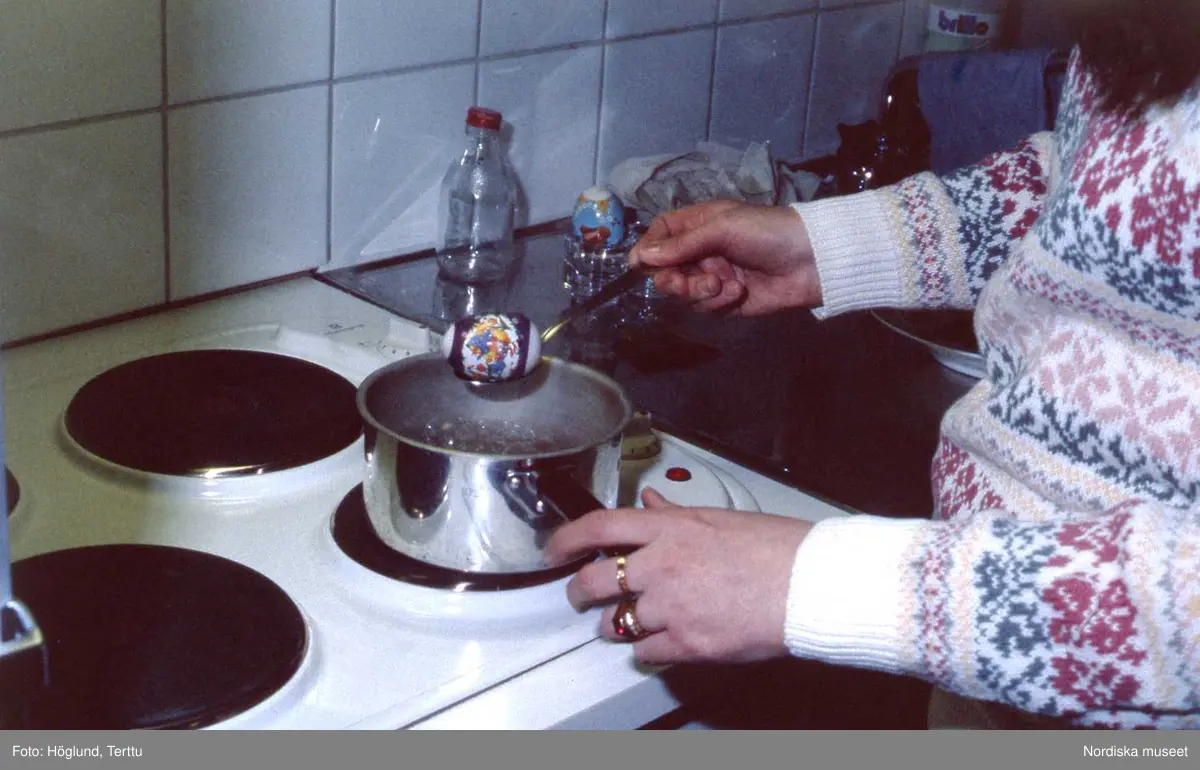 Caroline Swensson kokar ägg och smälter dekoration på äggen.
