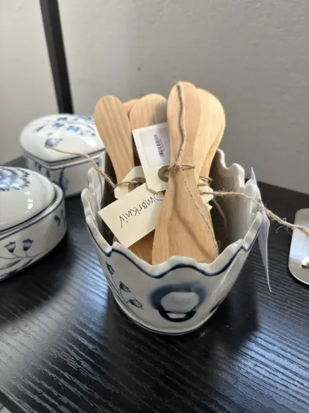 En samling smørkniver i tre i en keramikk-bolle.