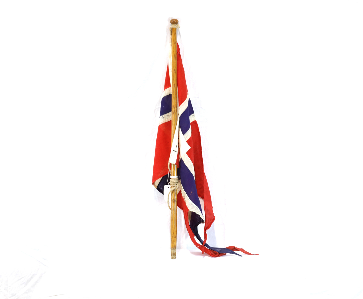 Flagg, rektangulært med splitt, på trestang. 
