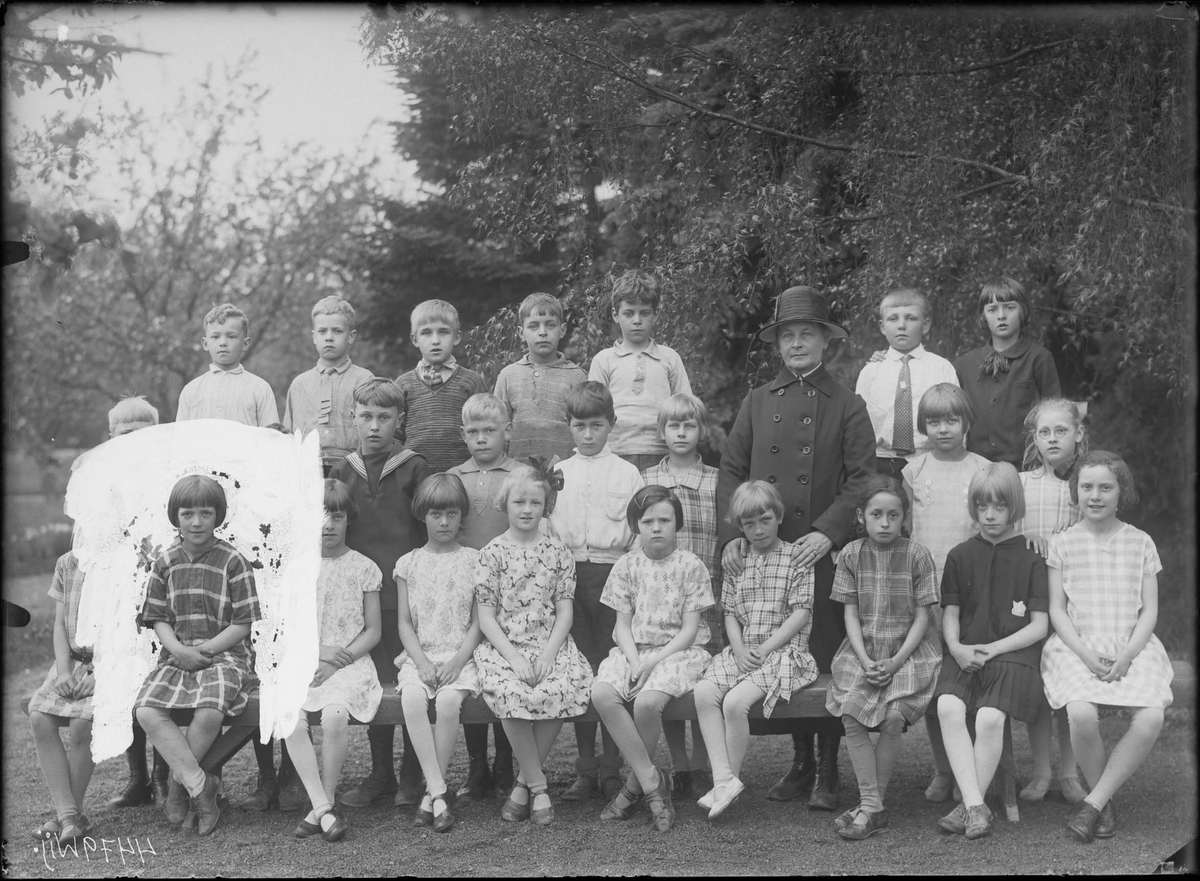 Lärarinnan är sannolikt Ester Maria Karlsson (1872-1948). Barnen är ej identifierade.