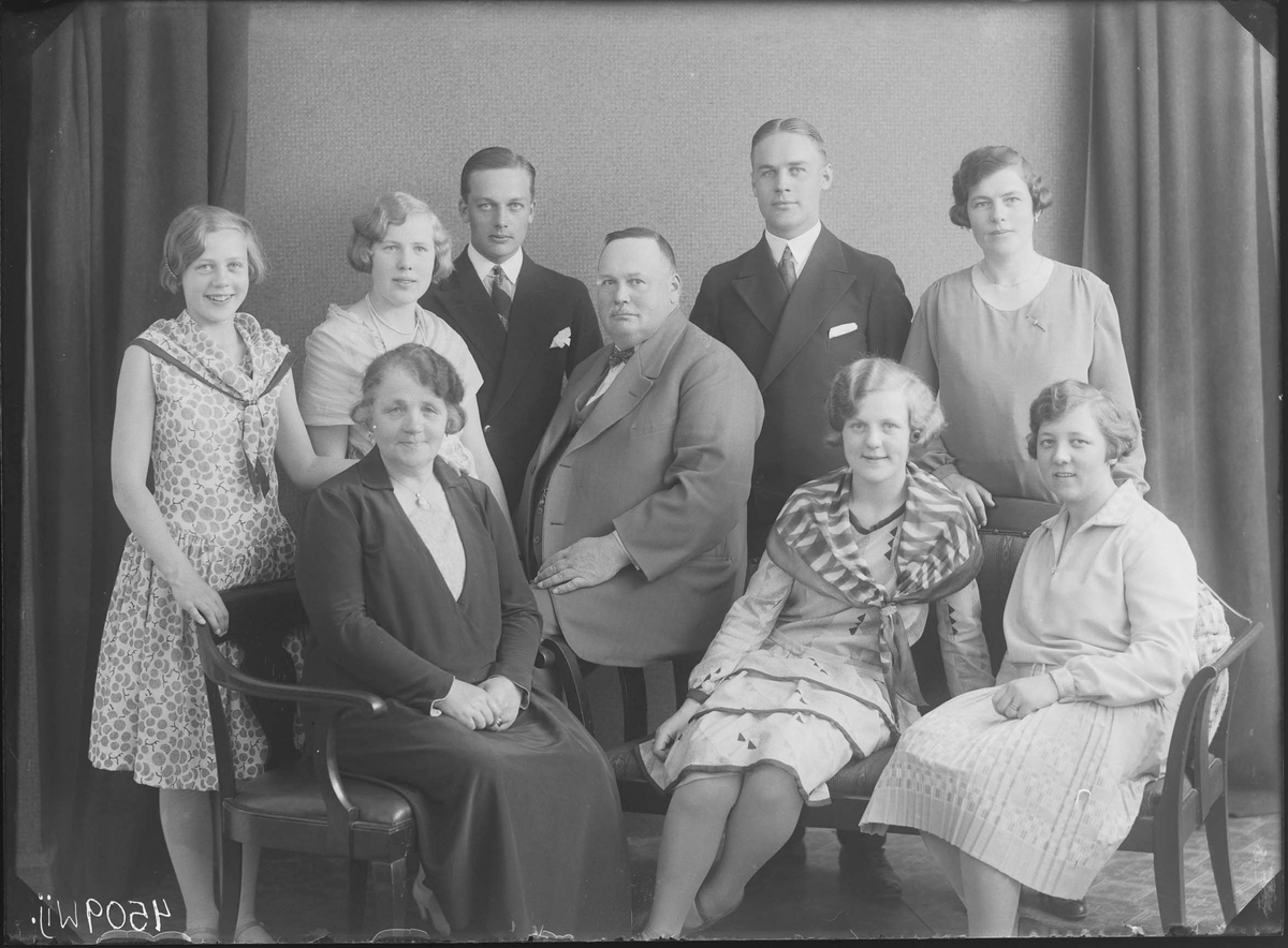 Fotografering beställd av Carl Emil Carlsson. Föreställer överkonstapeln Karl Emil Karlsson (1875-1941) ståendes i mitten, med hans hustru Anna Eugenia Hellström (1873-1962) sittandes till vänster om honom. De omgivs av barnen Anna Margareta Kristina (1898-1981), Klas Emil Henry (1903-1985), Karl Erik Martin (1907-1976), Brita Mariana (1912-2009), Stina Eugenia (1912-2006) och Inga Maria (1915-1950). En av kvinnorna är ej identifierade. Barnen tog efternamnet Gesteby.