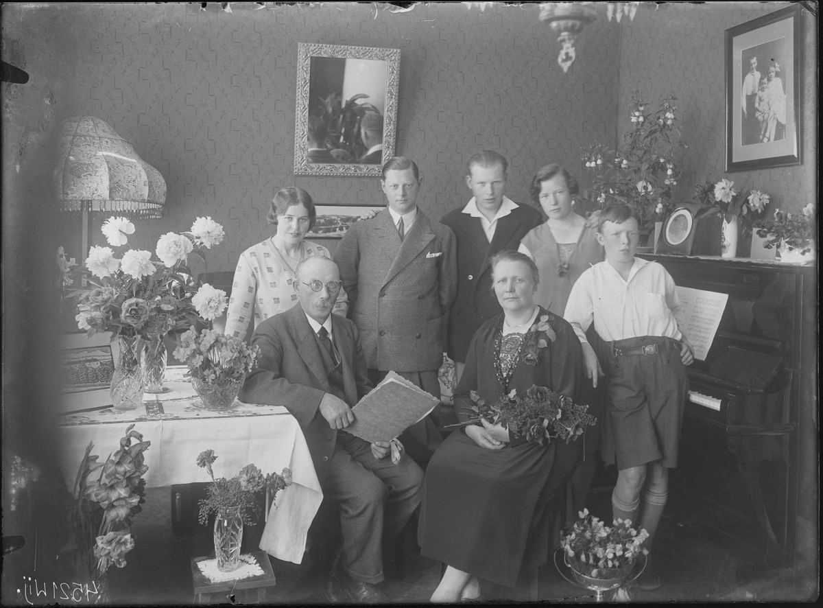 Fotografering beställd av Hammarsten. Föreställer sannolikt Frida Elisabet Lilja (1879-1943) som firar sin 50-årsdag den 18 juli 1929. Till vänster sitter hennes man slöjdläraren Vilhelm Alexander Hammarsten (1875-1966). De omges av sina barn.