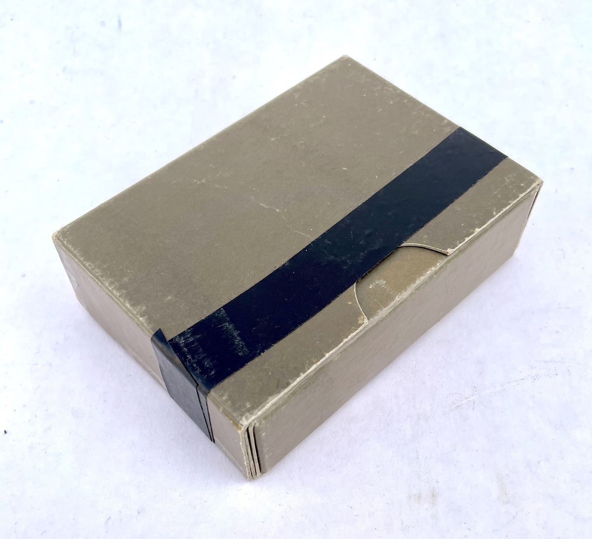 En nödportion i en olivgrön kartong med måtten 115 x 80 x 35 mm som består av två halvor – en ytterdel och en innerdel. Kartongen har ett varv svart el-tape runt ytterdelen. 
Kartongen innehåller en bruksanvisning, en stång med åtta bitar torkat rökt kött, fyra stänger med vardera åtta bitar fruktkarameller (ananas, citron, jordgubbe och aprikos), en portion snabbkaffe (cafe Salvador ”espresso” type), en tepåse, (Tetley) samt två 6,5g portionsförpackningar strösocker (Sockerbolaget).

Bruksanvisningens framsida har texten:
”NÖDPORTION ca 1000 kcal
Innehåll:
4 st. stänger á 8 bitar fruktkarameller
1 st. stång med 8 bitar torkat rökt kött
1 port fp kaffe
1 port fp te
2 port fp strösocker

Näringsvärde:
153 g kolhydrater (huvudsakligen i fruktkaramellerna)
20 g protein (huvudsakligen i köttstången)
32 g fett (ca hälften i karamellerna och hälften i köttstången)
Bruksanvisning:
Nödportionens sammansättning är från näringsfysiologisk synpunkt sådan, att prestationsförmågan bibehålles, om portionen äts enligt omstående anvisningar”

Bruksanvisningens baksida har texten:
”1. Nödportionen skall fördelas på flera mindre måltider (minst 8 st).
2. Fruktkarameller och köttbitar skall ätas omväxlande
(Proteininnehållet härrör nästan uteslutande från köttkomponenten och kolhydratinnehållet från fruktkomponenterna.)
Anm.
Nödportionen förorsakar ej onormal törst; ett vätskeintag om 1 l/dygn är tillräckligt (förutom i situationer där stark svettning uppträder).
BLÅ BAND PRODUKTER AB, HALMSTAD
TILLVERKAD jan 1972”