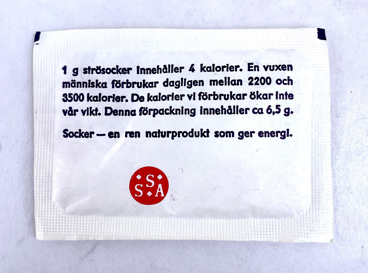 En nödportion i en olivgrön kartong med måtten 115 x 80 x 35 mm som består av två halvor – en ytterdel och en innerdel. Kartongen har ett varv svart el-tape runt ytterdelen. 
Kartongen innehåller en bruksanvisning, en stång med åtta bitar torkat rökt kött, fyra stänger med vardera åtta bitar fruktkarameller (ananas, citron, jordgubbe och aprikos), en portion snabbkaffe (cafe Salvador ”espresso” type), en tepåse, (Tetley) samt två 6,5g portionsförpackningar strösocker (Sockerbolaget).

Bruksanvisningens framsida har texten:
”NÖDPORTION ca 1000 kcal
Innehåll:
4 st. stänger á 8 bitar fruktkarameller
1 st. stång med 8 bitar torkat rökt kött
1 port fp kaffe
1 port fp te
2 port fp strösocker

Näringsvärde:
153 g kolhydrater (huvudsakligen i fruktkaramellerna)
20 g protein (huvudsakligen i köttstången)
32 g fett (ca hälften i karamellerna och hälften i köttstången)
Bruksanvisning:
Nödportionens sammansättning är från näringsfysiologisk synpunkt sådan, att prestationsförmågan bibehålles, om portionen äts enligt omstående anvisningar”

Bruksanvisningens baksida har texten:
”1. Nödportionen skall fördelas på flera mindre måltider (minst 8 st).
2. Fruktkarameller och köttbitar skall ätas omväxlande
(Proteininnehållet härrör nästan uteslutande från köttkomponenten och kolhydratinnehållet från fruktkomponenterna.)
Anm.
Nödportionen förorsakar ej onormal törst; ett vätskeintag om 1 l/dygn är tillräckligt (förutom i situationer där stark svettning uppträder).
BLÅ BAND PRODUKTER AB, HALMSTAD
TILLVERKAD jan 1972”