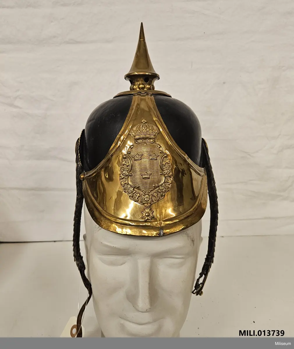 Kask av läder med mässingsdetaljer.