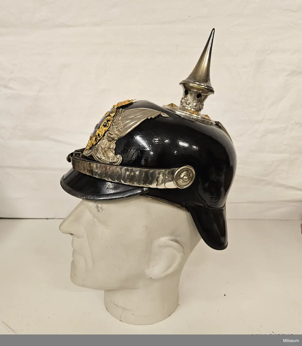Kask av läder med detaljer av försilvrad mässing. Med tillhörande paradplym av tagel och förvaringslåda av läder.