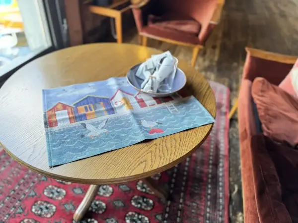 Nydelig dekkebrikke med mønster av sjø, sjøboder og sjøfugler