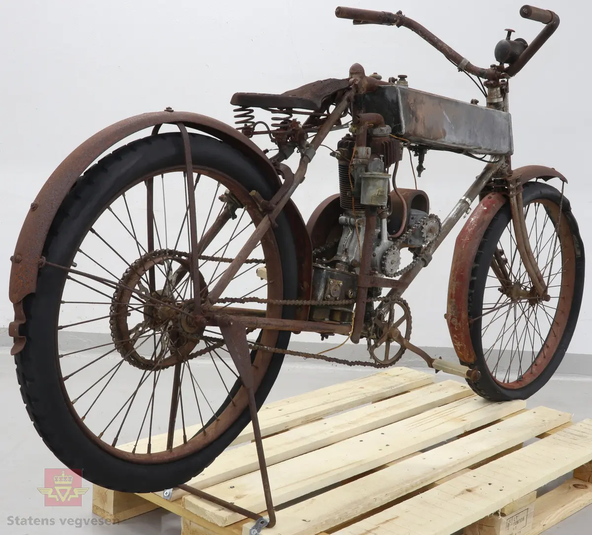 Motorsykkel med sort ramme og røde skjermer. Den har en enkel oppbygning som en motorisert tråsykkel med pedaler. Motor er en ensylindret firetaktsmotor, trolig en 120cc på 2  1/2 hk.
Motor er merket Lamaudiere no 528.
Opprinnelig var motorsykkelen levert med reimdrift, men har fått påbygd girkasse og kjededrift.
Bærer preg av lang tids lagring og har mye overflaterust. Motor og en del andre bevegelige deler sitter fastrustet.
