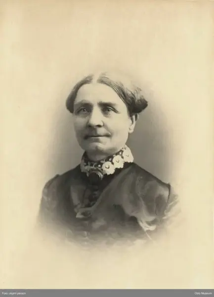 Historisk portrett av en eldre kvinne med oppsatt hår.