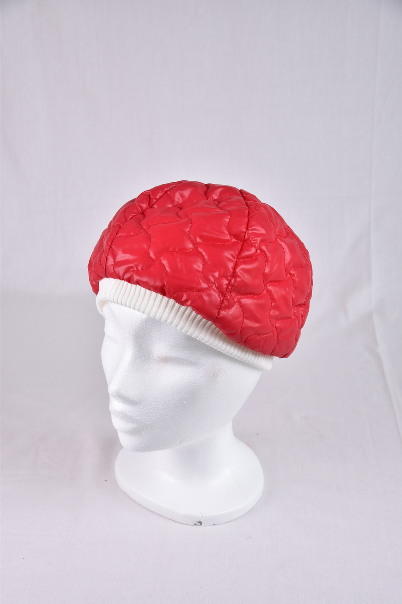 Vinterlue i rødt kunststoff. Hvit pyntekant og knapp på toppen.