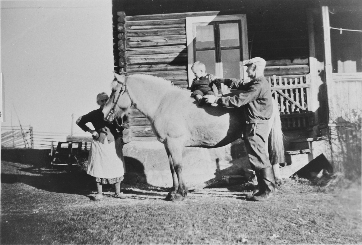Foran gamlebygningen på Skatvedt, 1946, Fra venstre: Beret Skatvedt (f. Hunstad), Per Arnfinn Grønhovd på hesten Blakken og Petter Skatvedt. 
