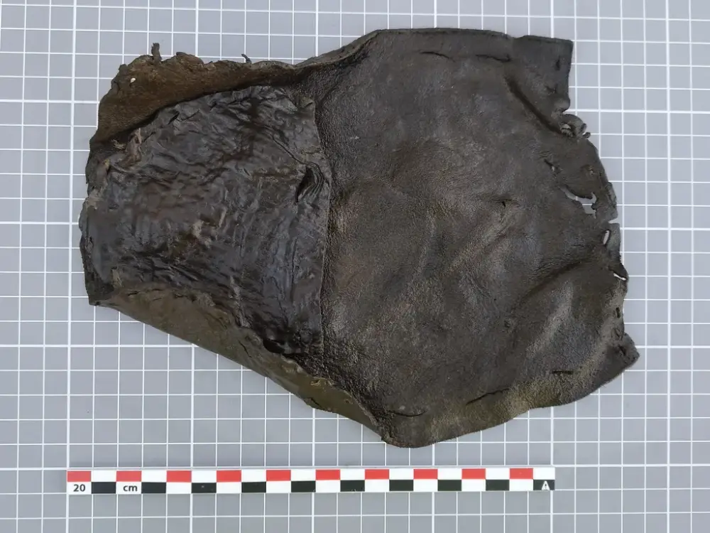 Fragment av barnesko fra middelalderen, laget av ett stykke mørkt lær, funnet ved Bjørvika skole.