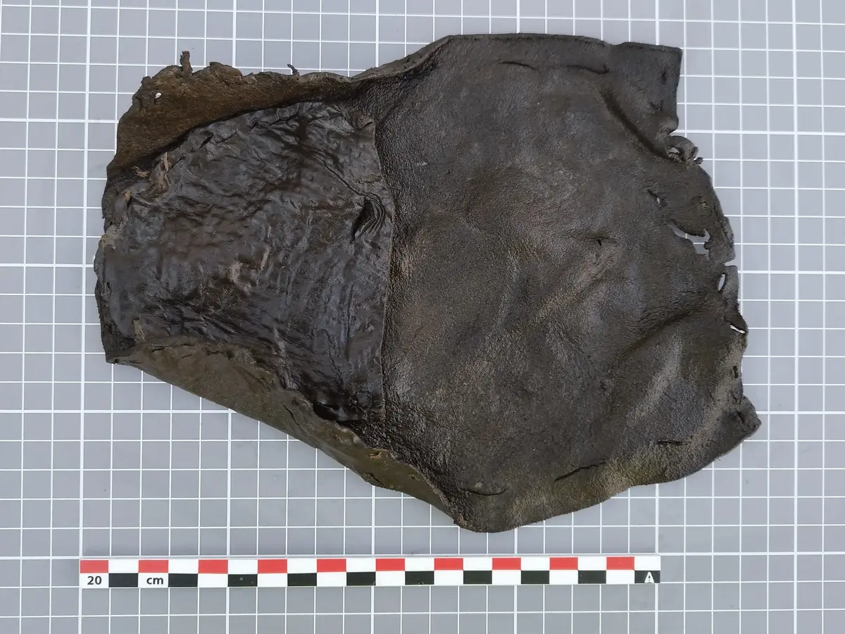 Fragment av barnesko fra middelalderen, laget av ett stykke mørkt lær, funnet ved Bjørvika skole.