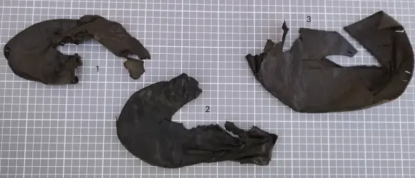 Tre fragmenterte middelalderske barnesko i lær, merket med 1, 2 og 3, funnet under arkeologiske utgravninger ved Bjørvika skole.