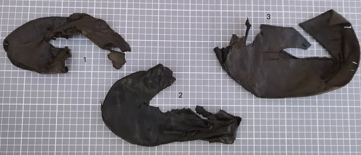 Tre fragmenterte middelalderske barnesko i lær, merket med 1, 2 og 3, funnet under arkeologiske utgravninger ved Bjørvika skole.