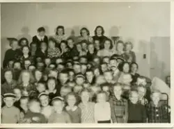 Samling til fest med Telavågborna på Storetveit skole i Bergen. Jenny og Ella Hjartøy saman med mange barn og unge frå Telavåg.