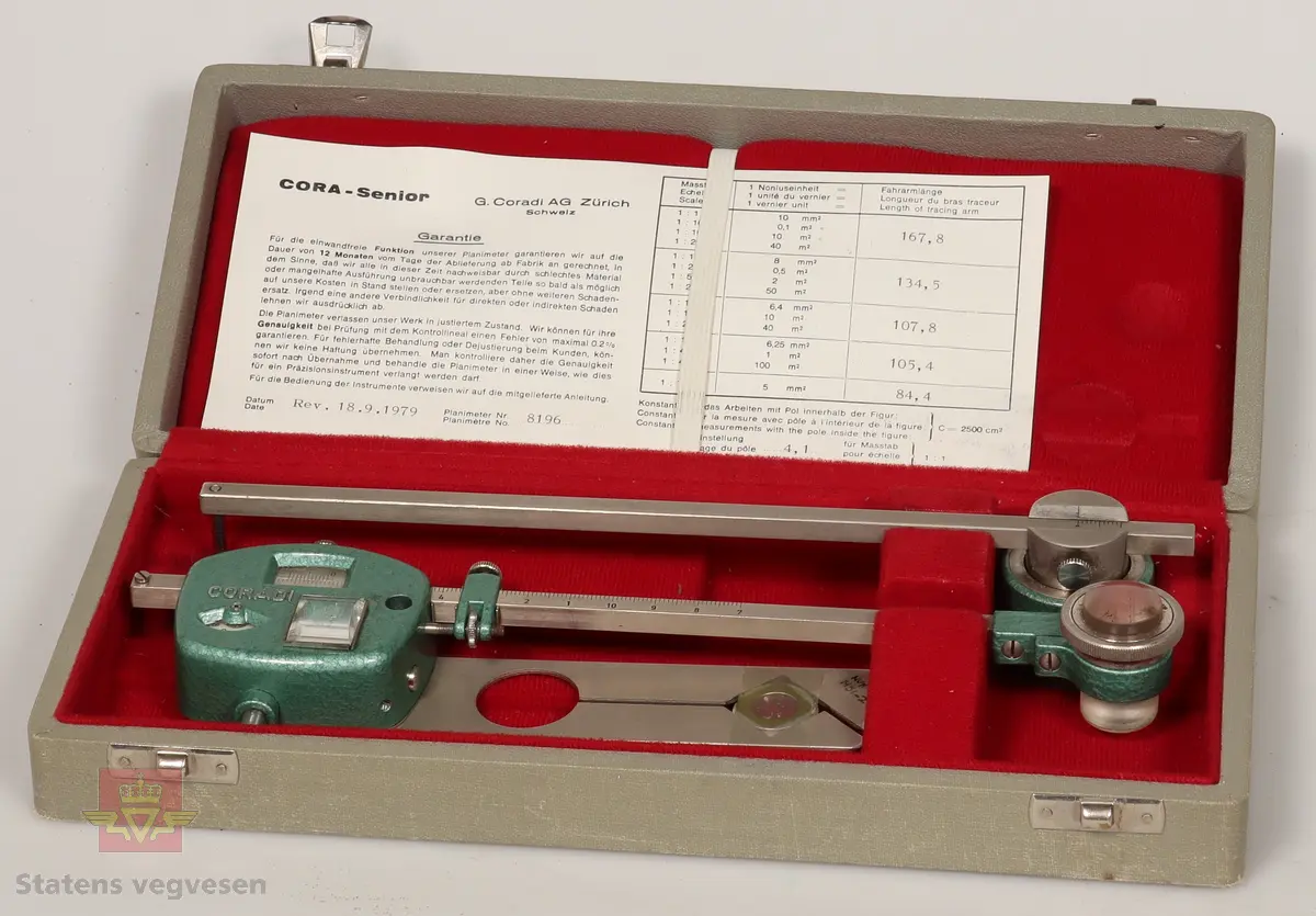 Planimeter av metall. Består av tre deler og garantikort. Ligger i et grått etui foret med rødt stoff på innsiden og låser av rustfritt stål. Hoveddelen har to roterende skalaer innebygd, og er malt med grønn hammerslagslakk. Ser ut til å være i topp stand. 

De andre delene i etuiet er som følge: 
NVM 01451 - 001 Metallstang med grønnmalt lodd i enden. Del av planimeter.
NVM 01451 - 002 Blank metallplate. Del av planimeter. 
NVM 01451 - 003 Garantikort av papir. Inneholder også noen tabeller. Svart skrift på hvit bakgrunn. 