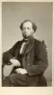 Odaterat porträtt av Carl Axel Agerholtz som bär 1860-talets prägel. Född i sörmländska Länna 1825 inflyttade han efter en tid som bokhållare vid Forssjö bruk till Norrköping för tjänst som kassör vid Motala Verkstads verksamhet. Vidare innehade han samma tjänst vid Norrköpings Träförädlings AB. Agerholtz framlevde sitt liv som ogift men öppnade under många år sitt hem för en äldre syster och hennes dotter.