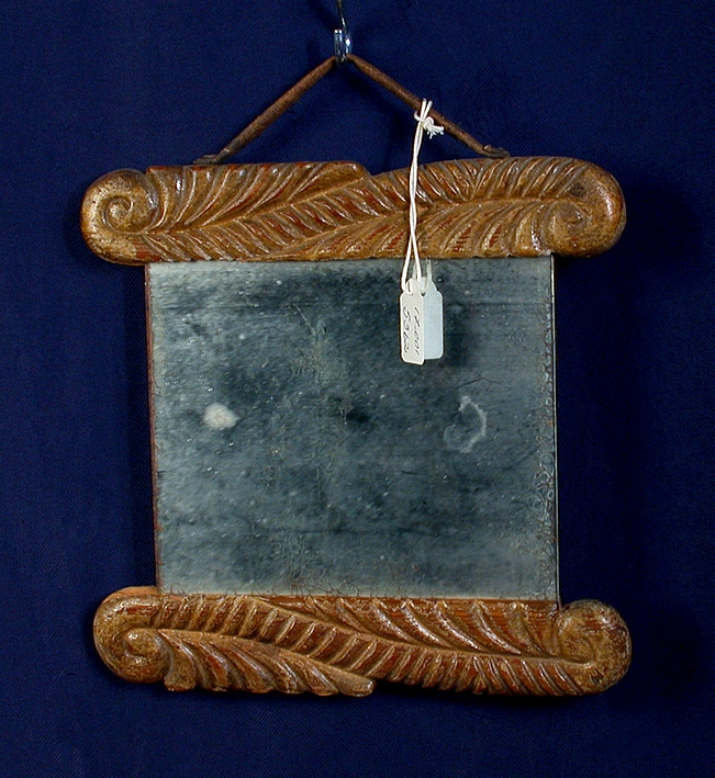 En över- och en underlist. Ornerade med växtmotiv. Brunmålad.
Mått: Spegeln: 180 x 145mm. Listerna: 240 x 40mm.