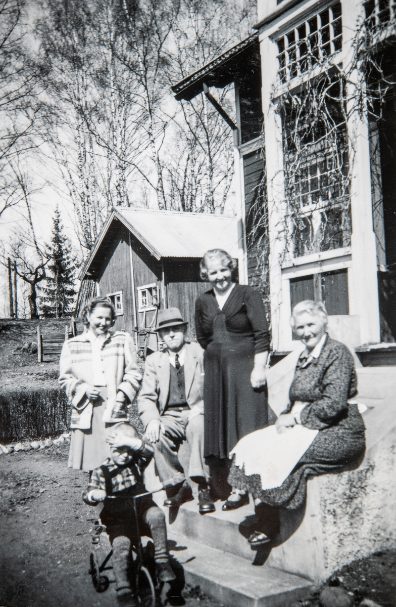 Ute på tunet i Lunde på Jessnes i 1946/47 Fra venstre Hjørdis Kristine Carlsen, hr og fru Karud fra Oslo, Inger Carlsen. Foran barnebarnet Knut Erling Engebretsen på trehjulsykkel.  Fotograf Ruth Engebretsen.