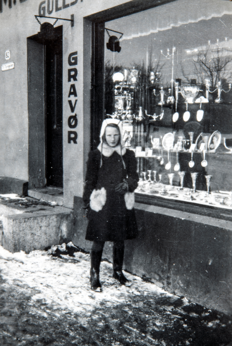 Else Kaulum ser i butikk vinduene til Gullsmed M. B. Michelsen på Stortorget i Hamar. Torggata 82.