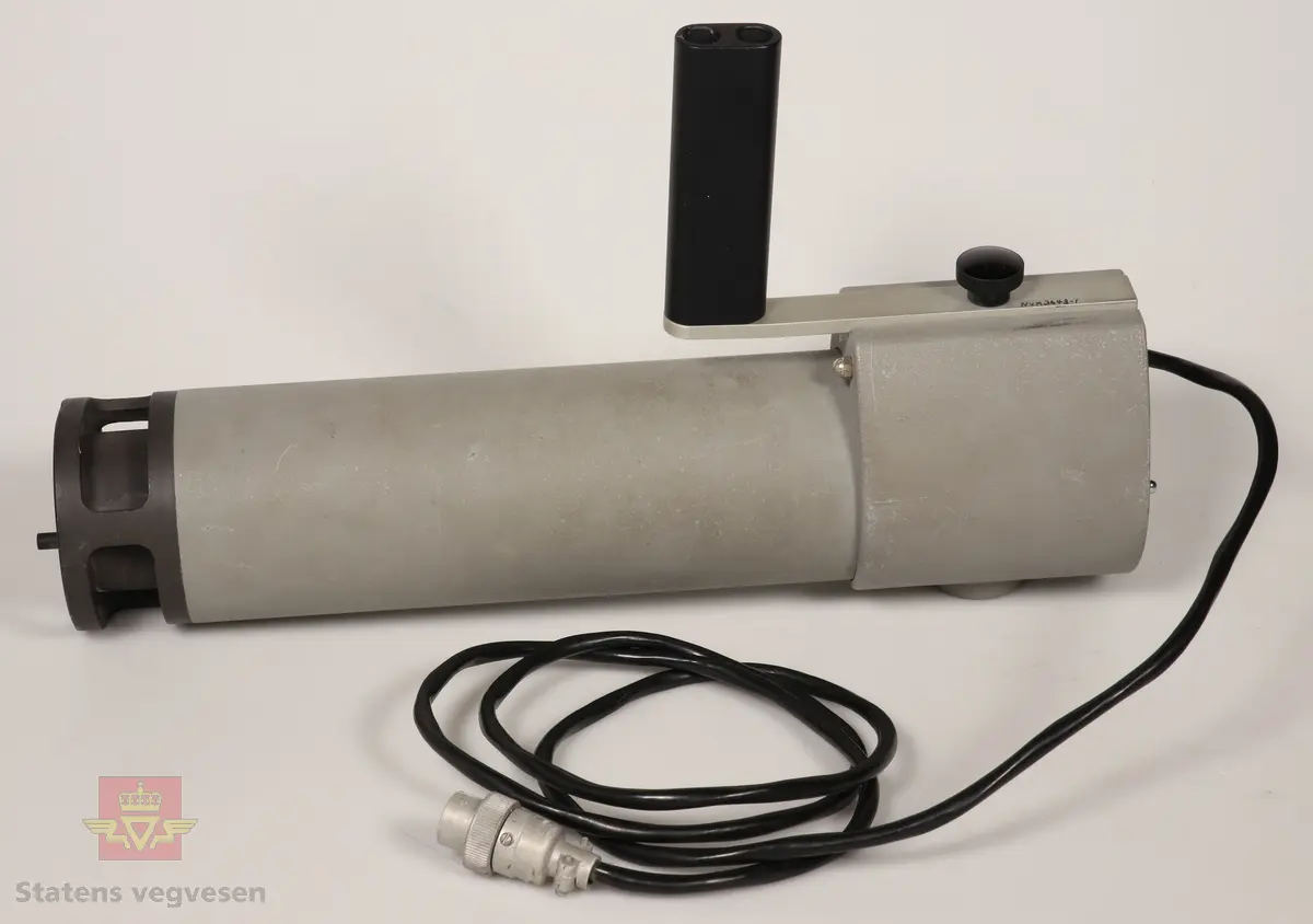 Refleksmåler som består av:

NVM 03643 Kontrolldelen er rektangulær og innkapslet i metall, svart og aluminiumsfarget med bærehåndtak og bærereim. Den har en bryter for innstilling og display for avlesning. Drives av 1 stk Varta 6V - 1EC 4R25 batteri. Dette er fjernet ved NVM. 
NVM 03643 - 001 Målehode med pistolgrep. Av metall, grå og svart. Svart kabel for tilkobling til kontrollenhet. Presses mot skilt.
NVM 03643 - 002 Treskrin med lokk som inneholder seks prøvedeksler for kalibrering av refleksmåler. Seks ulike farger. 
NVM 03643 - 003 Bruksanvisning og beskrivelse i blå perm. Svart skrift på hvitt. 
NVM 03643 - 004 Finerkasse med lokk. Forsterket med metallprofiler. Bærehåndtak.

Utstyret ser ut til å være i bra stand, men vi vet ikke om det fungerer. 