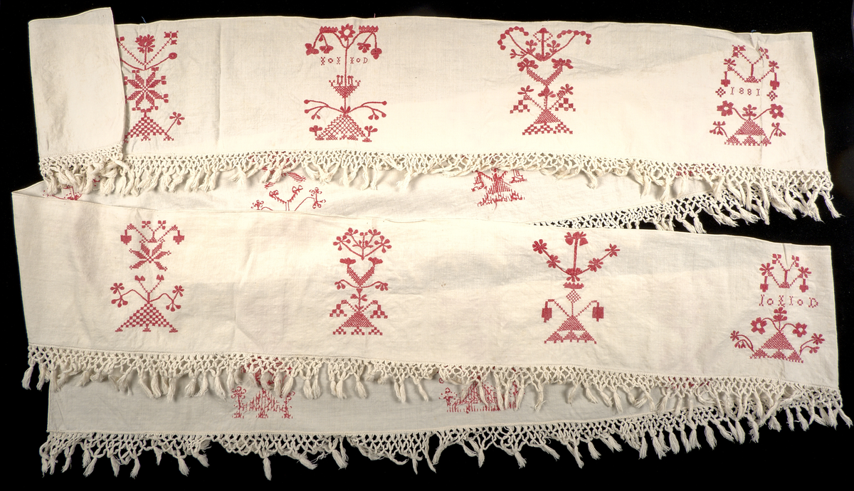 Hängkläde i vit bomullslärft, dekorerat med broderi i hallandssöm med rödfärgad bomullstråd. Broderierna utgörs av sammanlagt femton unika motivpartier, placerade längs klädets längd. I det fjärde motivpartiet från höger samt det andra från vänster finns monogram med ej identifierade initialier: "IL ID"?. I det fjärde motivpartiet från vänster återfinns årtalet 1881.

Motivpartierna är placerade med ojämna mellanrum längs textilen. Broderierna uppvisar variation i utförande. Tygstycket är oregelbundet klippt och fållat.
