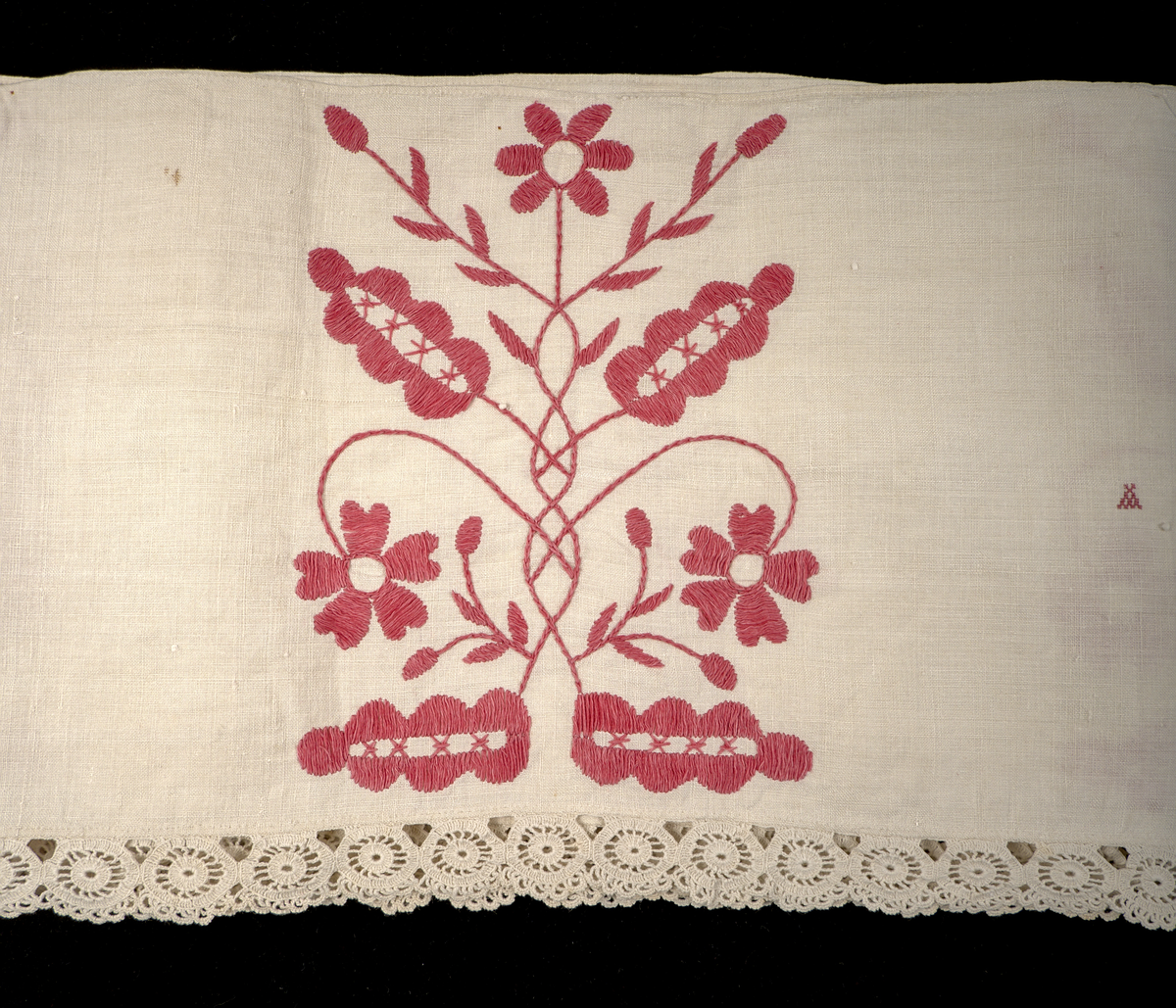 Hängkläde i vit linnelärft, dekorerat med broderi i hallandssöm med rödfärgad bomullstråd. Broderierna utgörs av två omväxlande mönsterpartier som upprepas sammanlagt tio gånger längs klädets längd. På klädets högra sida två uppsättningar monogram i korsstygn: "AC ND", samt årtalet 1869. Hängklädet är sammansatt av tre tygstycken. Samtliga kanter är fållade. Den nedre fållen är försedd med en knypplad bård i hjulformade mönster.