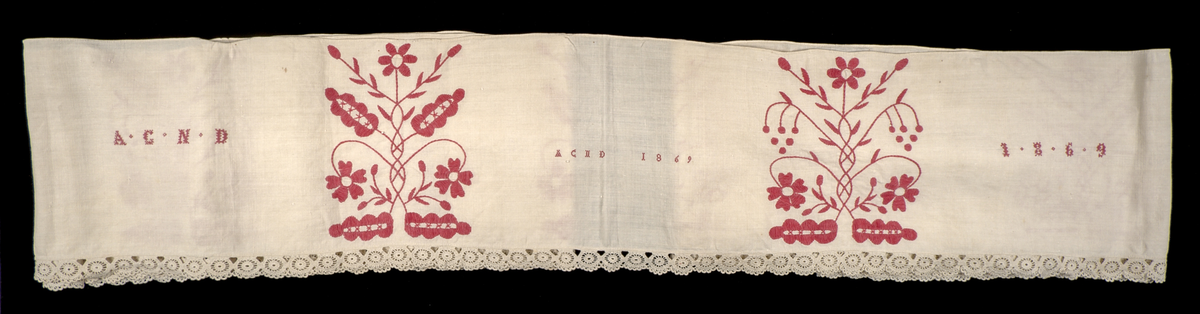 Hängkläde i vit linnelärft, dekorerat med broderi i hallandssöm med rödfärgad bomullstråd. Broderierna utgörs av två omväxlande mönsterpartier som upprepas sammanlagt tio gånger längs klädets längd. På klädets högra sida två uppsättningar monogram i korsstygn: "AC ND", samt årtalet 1869. Hängklädet är sammansatt av tre tygstycken. Samtliga kanter är fållade. Den nedre fållen är försedd med en knypplad bård i hjulformade mönster.