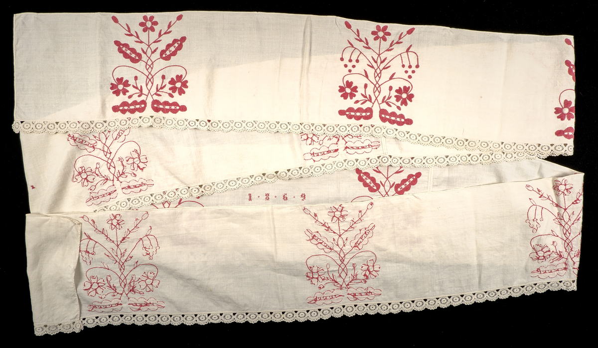 Hängkläde i vit linnelärft, dekorerat med broderi i hallandssöm med rödfärgad bomullstråd. Broderierna utgörs av två omväxlande mönsterpartier som upprepas sammanlagt tio gånger längs klädets längd. På klädets högra sida två uppsättningar monogram i korsstygn: "AC ND", samt årtalet 1869. Hängklädet är sammansatt av tre tygstycken. Samtliga kanter är fållade. Den nedre fållen är försedd med en knypplad bård i hjulformade mönster.