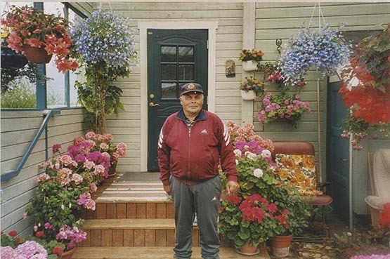 Fotografi av lyngshest, Leif Larsen og hans foreldre, Hans Leonhard Larsen og Astrid Helene Larsen. Hans L. Larsen med hest og plog. Leif Larsen med hest og føll, samt på trappa omgitt av blomster han selv dyrket.
