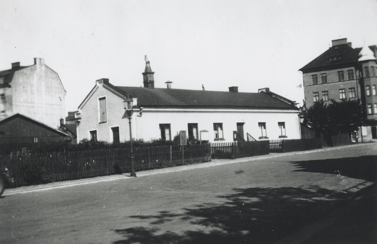 Reprofotografi av en bild på Filadelfiakyrkan i Kalmar. Pingstförsamlingen bildades 1919 och efter att ha hyrt in sig i IOGT-lokalen på Strömgatan 19 övertog församlingen Henning Papenhagens cikoriafabrik, som bilden visar, på Smålandsgatan 1C/1D, nuvarande Framsta 9. Byggnaden revs 1934 och 1935 kunde församlingen flytta in i nya lokaler på tredje våningen i det nybyggda huset (se KLMF.O16002S). År 2012 flyttade församlingen till nya lokaler, Lorensbergskyrkan, som ritades av Engstrand och Speek AB.