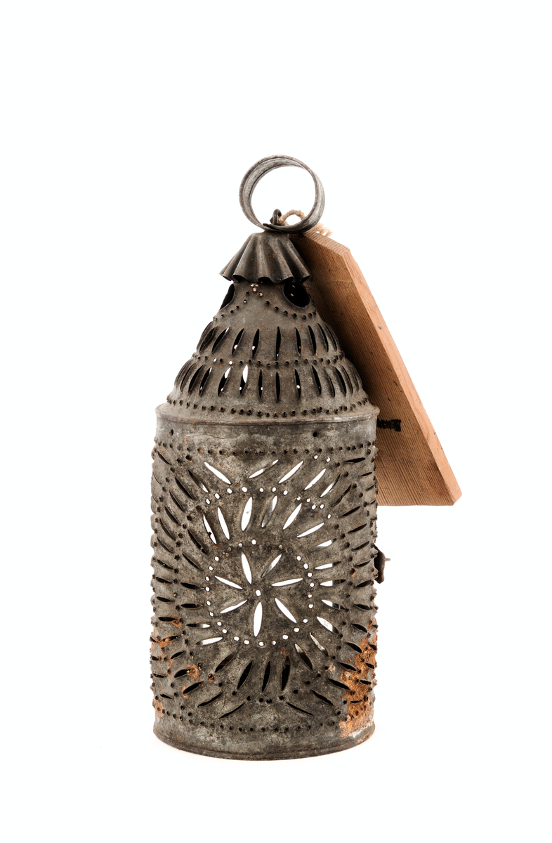 Perforert blekksylinder med glasdør og handtak.

